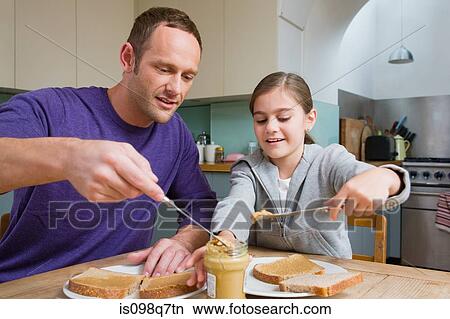 Picture - Father and daughter making sandwiches. Fotosearch