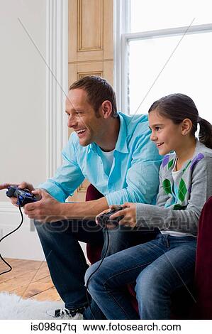 Stock Photography - Father and daughter playing video game. Fotosearch