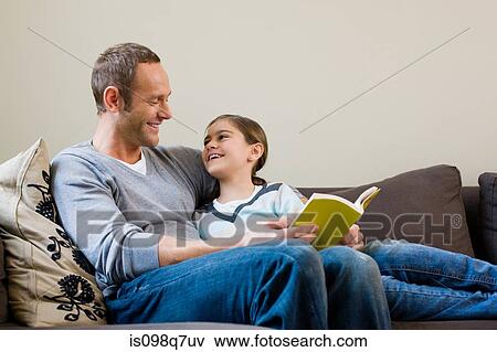 Stock Photo - Father and daughter reading a book together. Fotosearch
