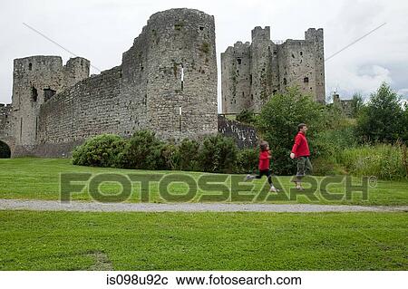 Stock Image - Father and daughter running at Trim Castle, County Meath, Ireland. Fotosearch