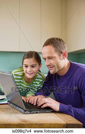 Picture - Father and daughter using laptop. Fotosearch
