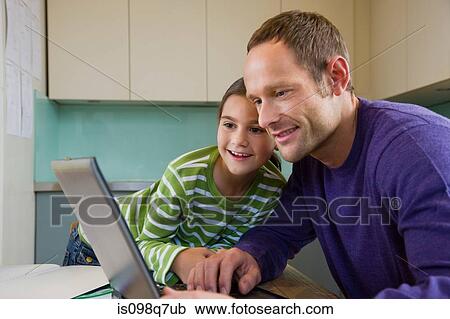Stock Image - Father and daughter using laptop. Fotosearch