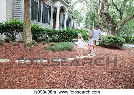 Picture - Father and daughters walking on garden path. Fotosearch