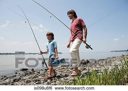 Father and son on beach with fishing rods View Large Photo Image Stock Photograph - Father and son on beach with fishing rods. Fotosearch