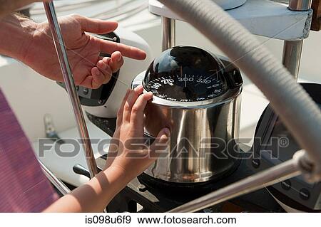 Father and son on board yacht, father pointing to speedometer View Large Photo Image Stock Photo - Father and son on board yacht, father pointing to speedometer. Fotosearch