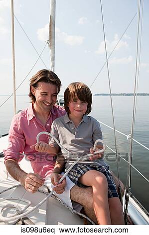 Father and son on board yacht holding rope View Large Photo Image Stock Photography - Father and son on board yacht holding rope. Fotosearch