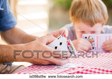 Stock Photo - Father and son playing card game. Fotosearch