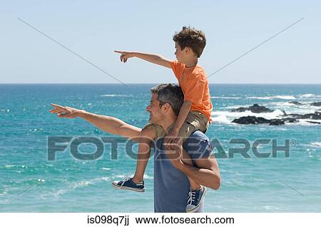 Father and son pointing at the sea View Large Photo Image Stock Image - Father and son pointing at the sea. Fotosearch