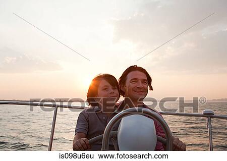 Stock Photograph - Father and son sailing yacht. Fotosearch