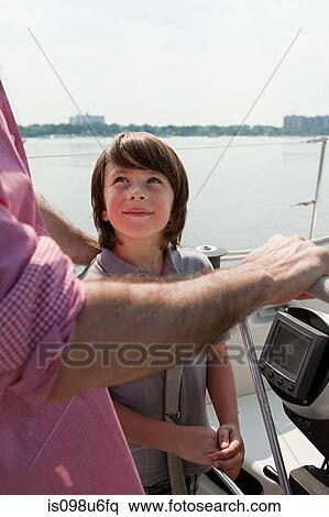 Stock Photography - Father and son sailing yacht. Fotosearch