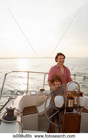 Picture - Father and son steering yacht. Fotosearch
