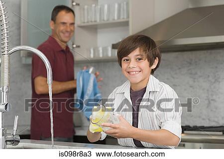 Stock Image - Father and son washing up. Fotosearch