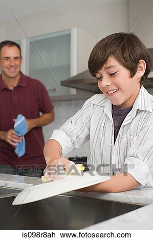 Stock Image - Father and son washing up. Fotosearch
