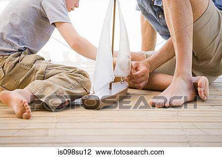 Father and son with toy boat View Large Photo Image Stock Image - Father and son with toy boat. Fotosearch