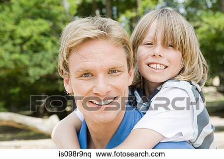 Father giving son a piggyback View Large Photo Image Stock Photography - Father giving son a piggyback. Fotosearch