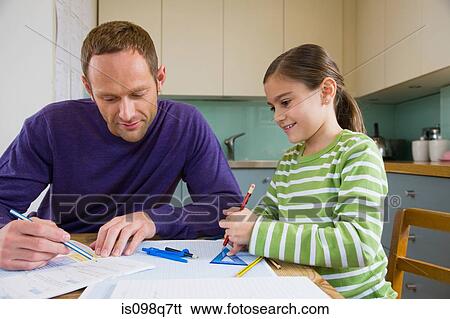 Stock Photograph - Father helping his daughter with homework. Fotosearch