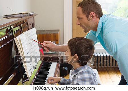 Picture - Father teaching son how to play the piano. Fotosearch