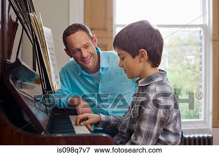 Stock Photo - Father teaching son how to play the piano. Fotosearch