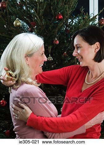 Female friends hugging at christmas View Large Photo Image Stock Image - Female friends hugging at christmas. Fotosearch