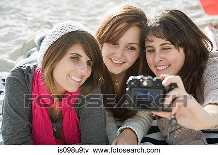 Female friends taking photograph of themselves View Large Photo Image Stock Photo - Female friends taking photograph of themselves. Fotosearch