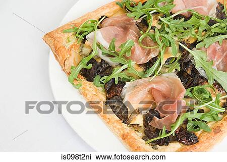 Filo pastry pizza topped with prosciutto, caramelized onion and rocket View Large Photo Image Stock Image - Filo pastry pizza topped with prosciutto, caramelized onion and rocket. Fotosearch