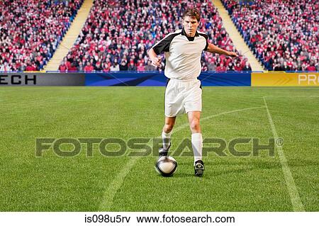 Stock Photo - Football player kicking the ball. Fotosearch