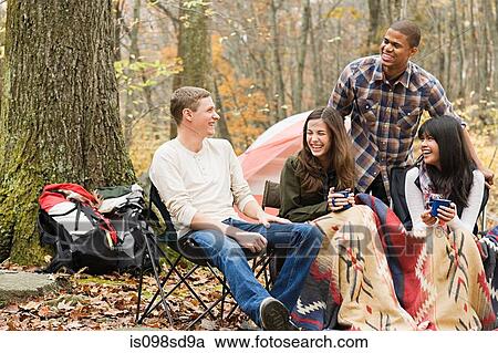 Stock Image - Friends at campsite. Fotosearch