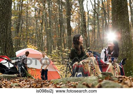 Stock Image - Friends at campsite. Fotosearch