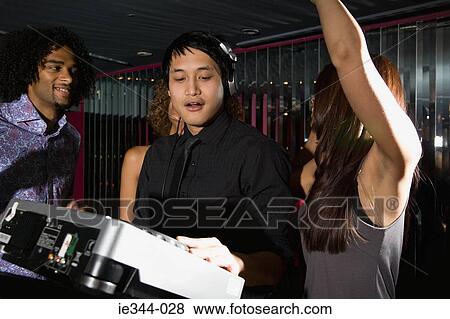 Friends dancing around a dj View Large Photo Image Stock Photo - Friends dancing around a dj. Fotosearch