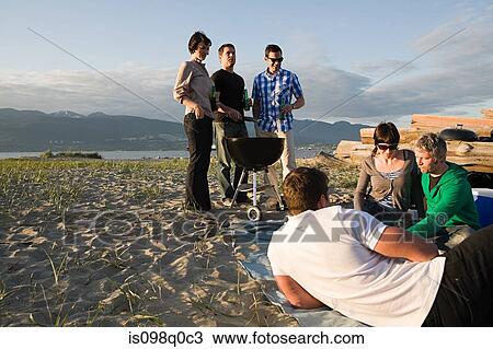 Stock Image - Friends having a barbecue on an island. Fotosearch
