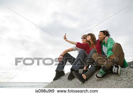 Friends taking photograph of themselves View Large Photo Image Stock Photo - Friends taking photograph of themselves. Fotosearch