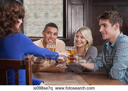 Friends toasting in bar View Large Photo Image Stock Photography - Friends toasting in bar. Fotosearch