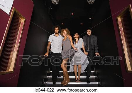 Friends walking down stairs in a nightclub View Large Photo Image Stock Image - Friends walking down stairs in a nightclub. Fotosearch