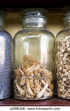 Stock Image - Ginseng roots in a jar. Fotosearch