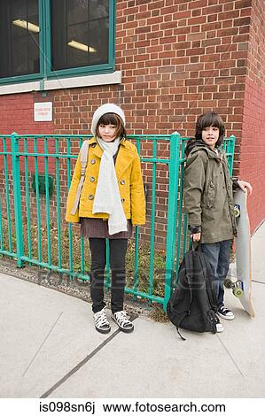 Stock Image - Girl and boy outside school. Fotosearch