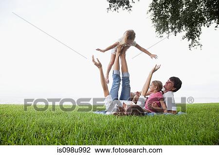 Girl balancing on feet of mother View Large Photo Image Stock Image - Girl balancing on feet of mother. Fotosearch