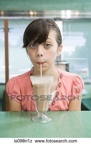 Girl drinking a milkshake View Large Photo Image Stock Photo - Girl drinking a milkshake. Fotosearch