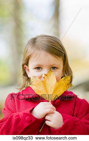 Stock Image - Girl holding a leaf. Fotosearch