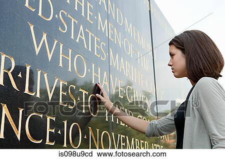 Stock Image - Girl looking at inscription of marine corps war memorial. Fotosearch