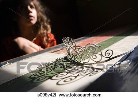 Girl looking at tiara on table View Large Photo Image Stock Image - Girl looking at tiara on table. Fotosearch