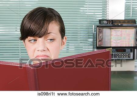 Stock Photograph - Girl looking disgusted with menu. Fotosearch
