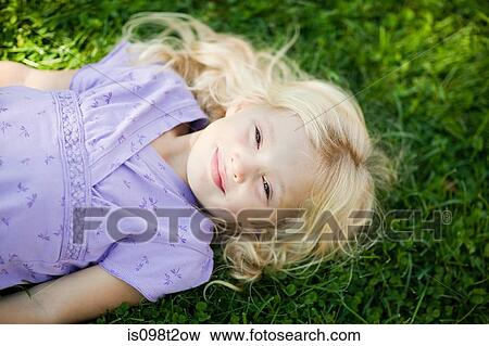 Girl lying on grass View Large Photo Image Stock Photo - Girl lying on grass. Fotosearch