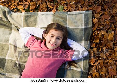 Girl lying on leaves View Large Photo Image Stock Photo - Girl lying on leaves. Fotosearch