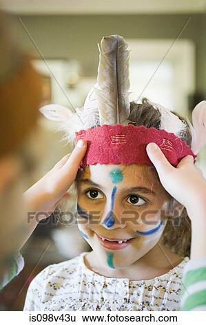 Stock Photograph - Girl putting Native American headdress on another girl. Fotosearch