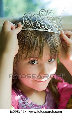 Girl putting on tiara View Large Photo Image Stock Photo - Girl putting on tiara. Fotosearch