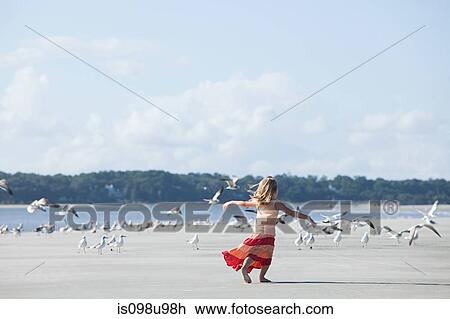 Girl running on beach amongst seagulls View Large Photo Image Stock Image - Girl running on beach amongst seagulls. Fotosearch