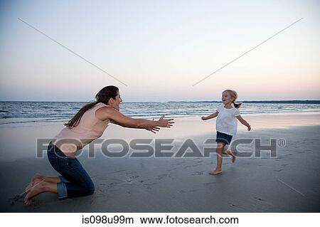 Picture - Girl running to mother on beach. Fotosearch