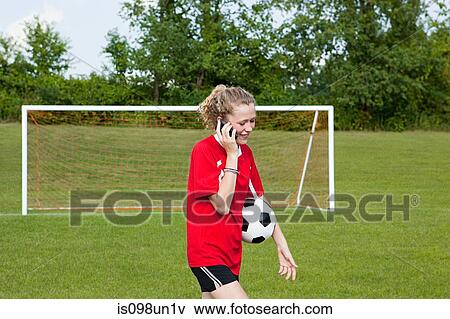 Stock Photo - Girl soccer player using cellphone. Fotosearch