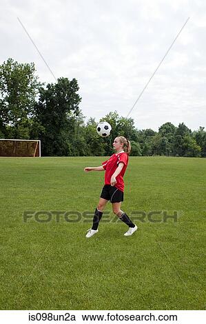 Stock Image - Girl soccer player with ball. Fotosearch
