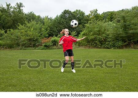 Stock Image - Girl soccer player with ball. Fotosearch